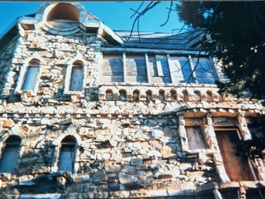 Historic stone castle facade with arched windows during renovation