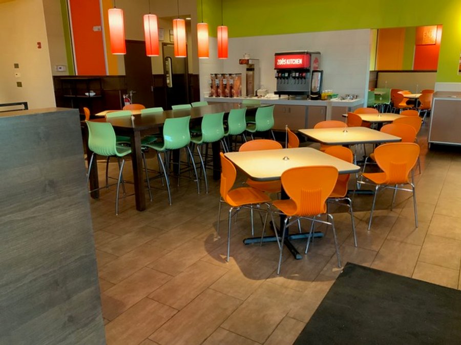 Finished fast-casual restaurant dining area with orange and green seating