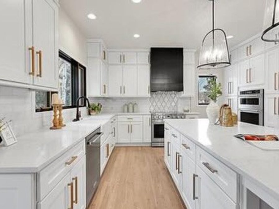 Finished kitchen with white shaker cabinets, quartz countertops, and brushed-gold hardware