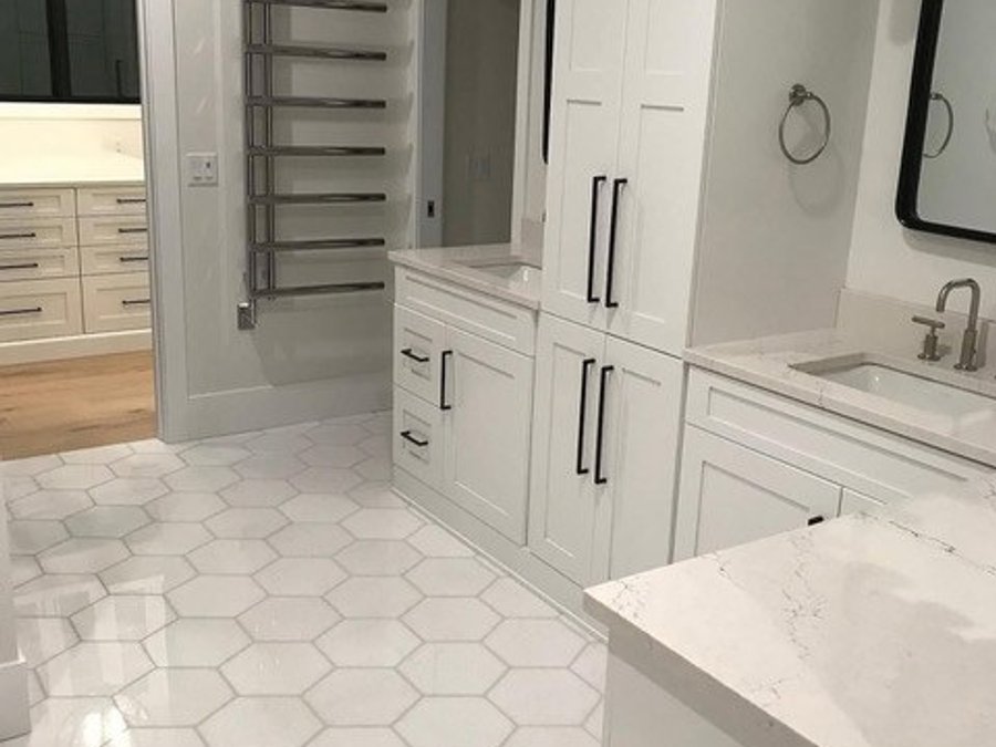 Luxury master bath with white shaker vanity, quartz countertop, hexagon tile flooring, and heated towel bar