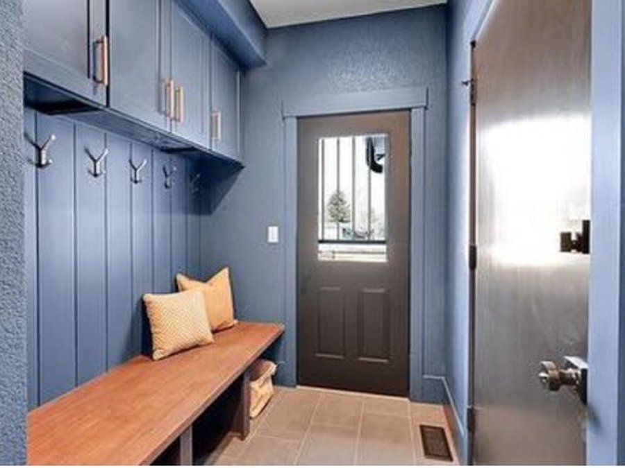 Mudroom with built-in bench, coat hooks, and blue board-and-batten cabinets