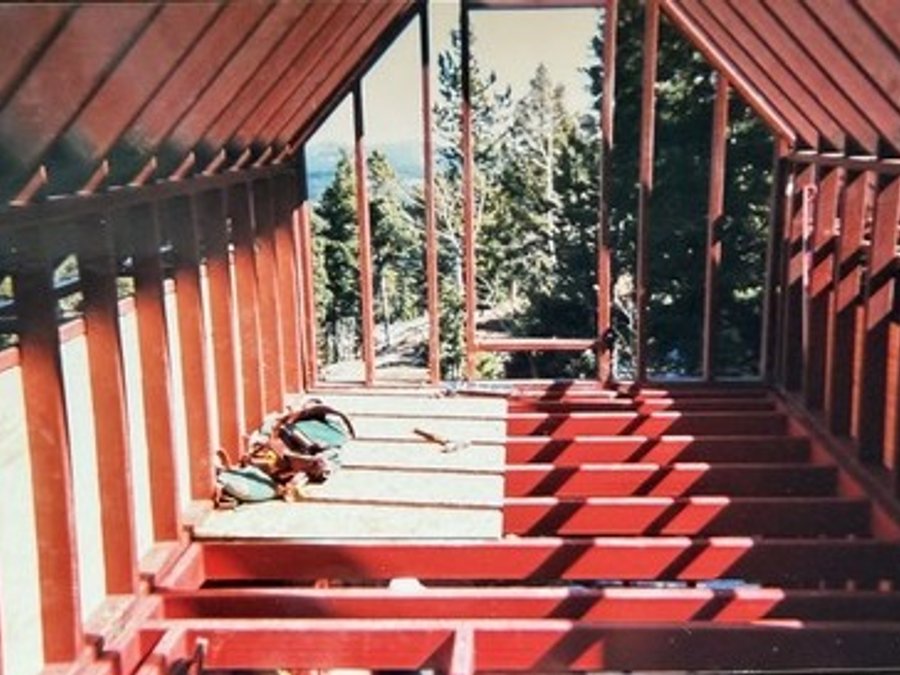 Castle renovation with structural steel roof framing against Colorado mountains