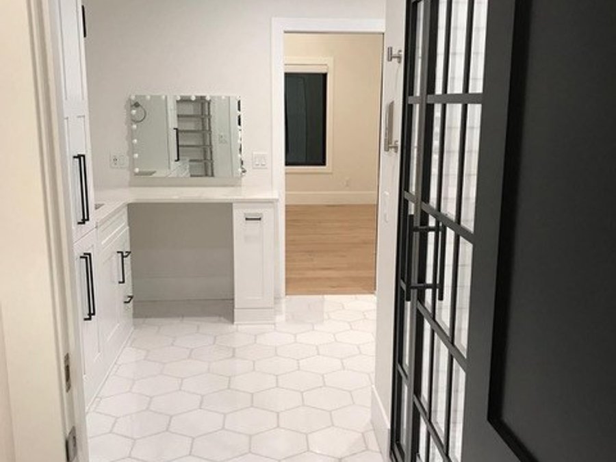 Master bath makeup vanity with Hollywood mirror and black steel-frame door