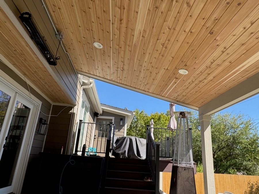 Cedar tongue-and-groove patio ceiling with integrated deck stairs in Colorado