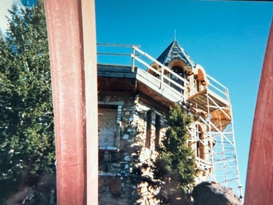 Castle exterior with scaffolding around a stone turret spire
