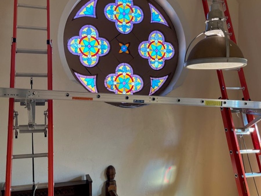 Cathedral rose window stained glass restoration with ladders and organ
