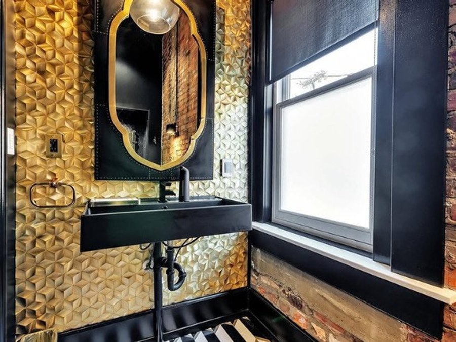 Office powder room with gold 3D tile, a matte-black floating sink, and exposed brick