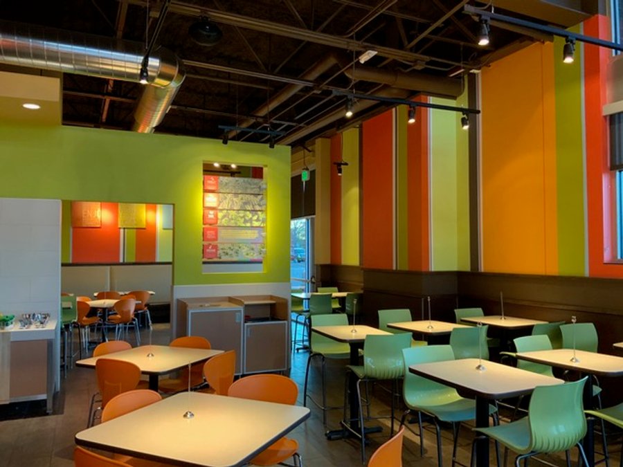 Restaurant tenant improvement with green and orange seating and booth dining, finished