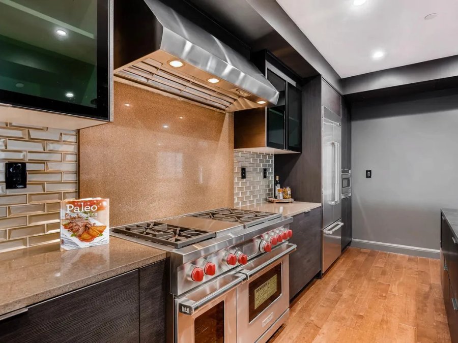 Ritz-Carlton penthouse kitchen with pro range, quartz countertops, and dark cabinetry