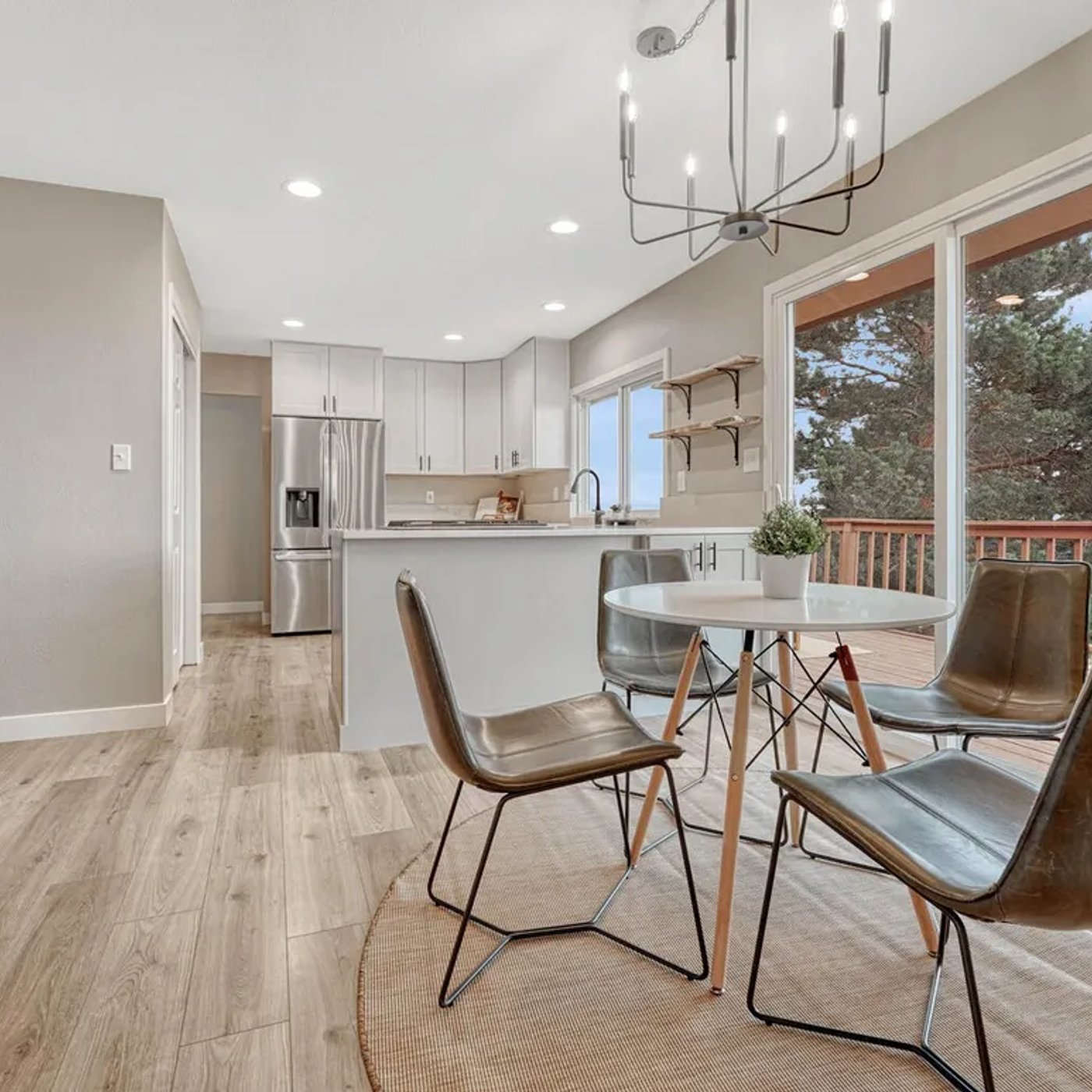 Finished open-plan kitchen and dining with hardwood floor, chandelier, and Colorado views by Engle Construction Group