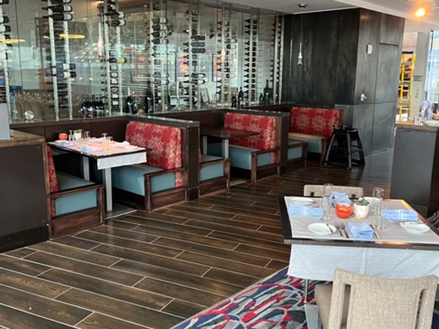 Finished hotel restaurant wine wall with booth seating and hardwood floor