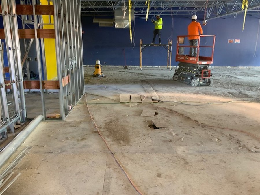 Commercial retail demo with steel framing and a scissor lift