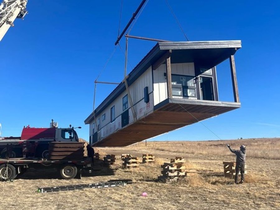Crane lifting a modular home section onto its foundation in Colorado